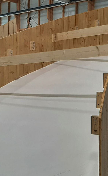 Nachtaufnahme einer STRABAG-Baustelle. Ein grosser Kran steht beleuchtet neben einem Wohnhaus unter dem klaren Nachthimmel.