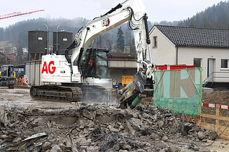 Weisser Bagger mit STRABAG Logo beim Abbruch der Wila Brücke