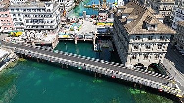 Bild zeigt Limmat, Rathaus und die Baustelle, davor die fertiggestellte Hilfsbrücke schräg angeordnet