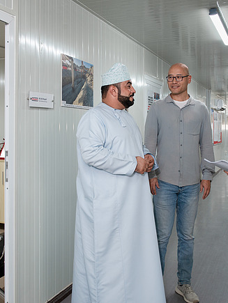 Leticia, technische Controllerin, bei ihrem Einsatz im Oman für STRABAG in einem Gesprächskreis mit zwei weiteren Kollegen