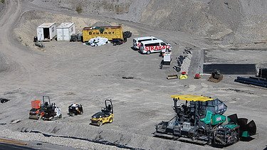 Ansicht auf das Areal mit Baumaschinen und Autos, Containern