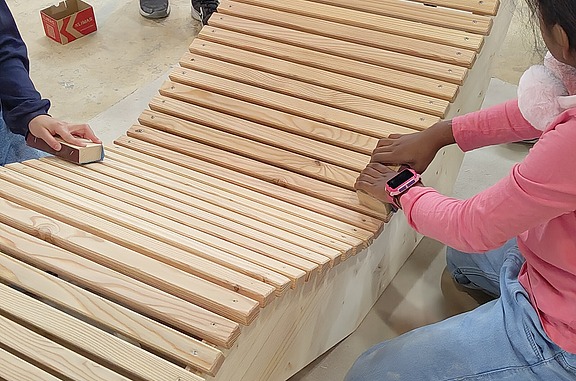 Zimmerin on Tour baut gemeinsam mit Primarschülern Holzliegen