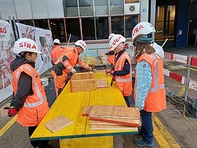 Mädchen mit Baustellenkleidung auf der Baustelle bekommen Arbeit erklärt