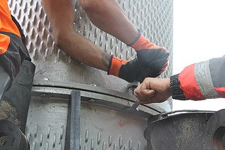 Nahaufnahme von zwei STRABAG Bauarbeitern, die an der Befestigung des Filterbrunnens arbeiten.