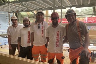 Gruppenfoto STRABAG Mitarbeitende mit Helmen und STRABAG-Shirts
