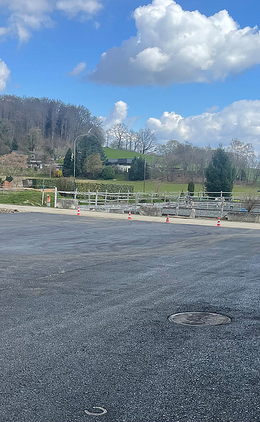 Nachtaufnahme einer STRABAG-Baustelle. Ein grosser Kran steht beleuchtet neben einem Wohnhaus unter dem klaren Nachthimmel.