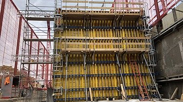 Foto von Arbeiten an einer gelben Holzschalung für Betonwände