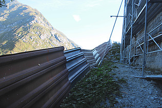 Ein Lawinenschutz und ein Gerüst auf einer Baustelle von STRABAG in den Schweizer Bergen.