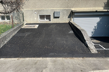 Nachtaufnahme einer STRABAG-Baustelle. Ein grosser Kran steht beleuchtet neben einem Wohnhaus unter dem klaren Nachthimmel.