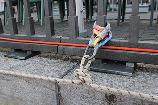 Ansicht von einen Knoten an einem Anschlagpunkt am Metallgeländer vom Holzsteg.