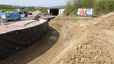 Foto von Graben für Leitungen mit STRABAG Bauzaunbanner im Hintergrund