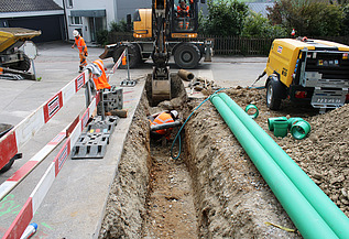 Foto von Arbeiten eines STRABAG Mitarbeitenden im Graben für Werkleitungen in Wangen mit