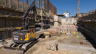 Bagger in der Baugrube unmittelbar zum Bahnhof Rüschlikon