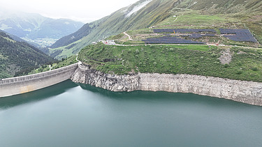 Berglandschaft mit dem Stausee Lai da Nalps im Vordergrund und Sicht auf die 20% der bereits verbauten Solarpanel