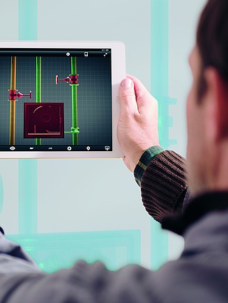 Person hält ein Tablet mit einer digitalen Bauplanansicht, die Linien und Messpunkte zeigt.