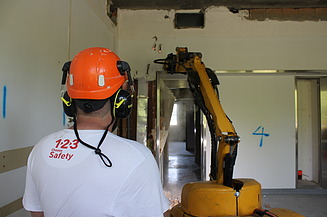 STRABAG Vorarbeiter mit Abbruchroboter beim Einreissen einer Wand.