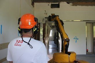 STRABAG Vorarbeiter mit Abbruchroboter beim Einreissen einer Wand.
