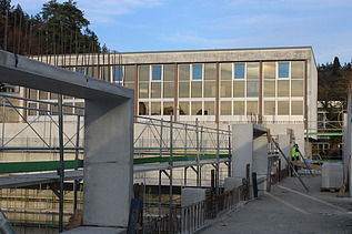 Foto vom Rohbau bis zur hälfte Hoch mit alter Schule im Hintergrund