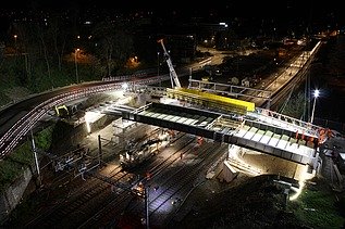Bild des Einbaus der Brücke bei Nacht über der Bahnlinie 
