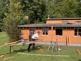 Zimmerer schneidet Lattung für die Fassade des Pfadiheims Hüttikerberg