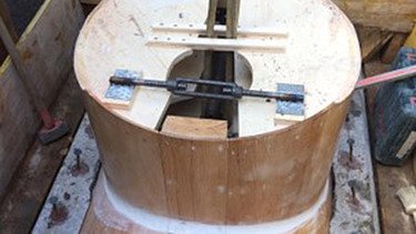 Zwei grosse Hebevorrichtungen auf einer STRABAG-Baustelle. Im Hintergrund sind Bauarbeiter:innen und ein Kran zu sehen.