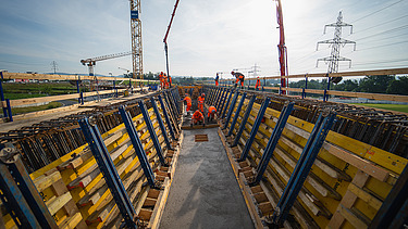 Nahaufnahme der Baustelle mit mehreren Kränen im Hintergrund