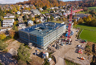 Drohnenaufnahme mit Kran und Schulhaus-Rohbau