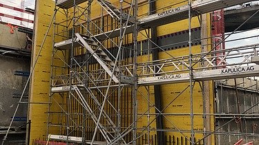 Foto von Arbeiten an einer gelben Holzschalung für Betonwände