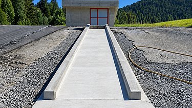 Schöne Perspektive entlang der Schussrinne mit Betriebsgebäude im Hintergrund