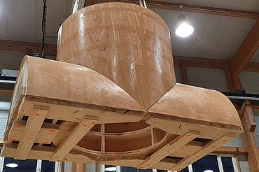 Nachtaufnahme einer STRABAG-Baustelle. Ein grosser Kran steht beleuchtet neben einem Wohnhaus unter dem klaren Nachthimmel.