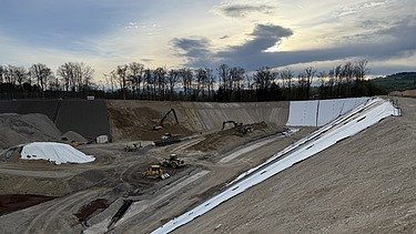 Steiles Gefälle im Burgauerfeld Wolkiger Himmel mit Sicht auf das steile Gefälle und Baumaschinen