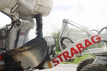 Asphaltierung in Olten an der Panoramastrasse - STRABAG Strassenbau Foto vom Abfüllen des Asphalts für Panoramastrasse mit STRABAG Bagger