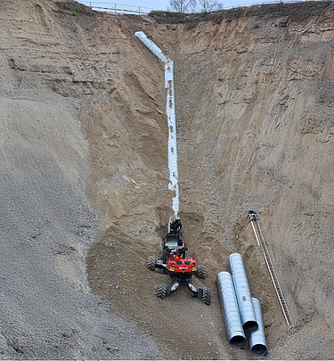 Foto von Bauarbeiten in einer Grube mit Menzi Mucki Bagger
