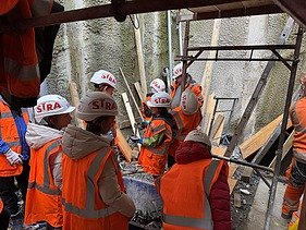Kinder des Zukunftstags beobachten auf der Baustelle die Schalungsarbeiten für die Wände des zukünftigen Pumpwerks Scheller.