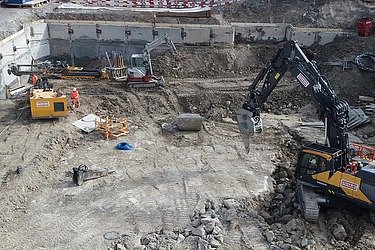 STRABAG - Bagger arbeiten in einer Baugrube für die neue Schulanlage Guggach in Zürich.
