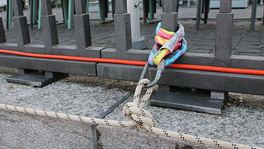 Ansicht von einen Knoten an einem Anschlagpunkt am Metallgeländer vom Holzsteg.