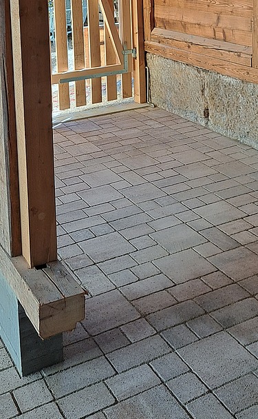 Draufsicht auf gepflasterten Boden mit neuen Fundamentpfeiler