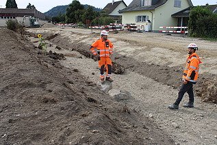 Der Bauführer und Polier sprechen im Flussbett miteinander