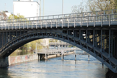 Stahlbrücke über einen Fluss in einer Stadt, aufgenommen im Rahmen von Instandsetzungsarbeiten.