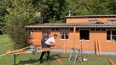 Zimmerer schneidet Lattung für die Fassade des Pfadiheims Hüttikerberg