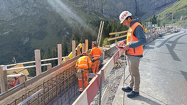 Der Bauführer auf der Passstrasse mit Blick auf die Baustelle leicht unterhalb des Strassenniveaus